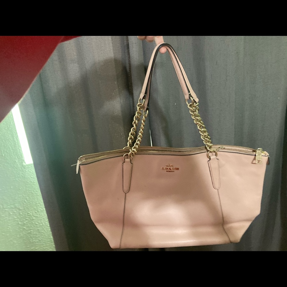Medium sized, light pink coach purse.